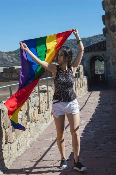 Young Woman Holding Raising Rainbow Flag Smiling Looking Side — Stockfoto