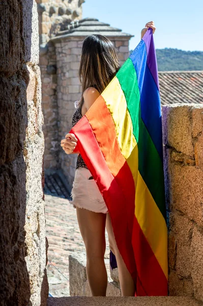 Young Woman Holding Raising Rainbow Flag Looking Horizon — Stockfoto