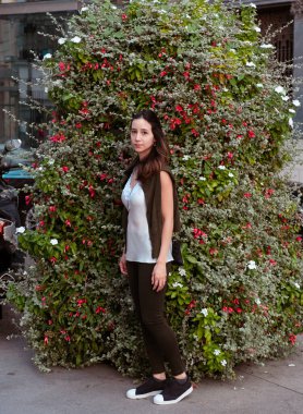 Bir ağacın önünde poz veren genç bir kadının portresi.