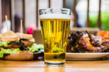  - Bira. Akşam yemeği kavramı, tavuk kızartması, salata, ahşap masada patates kızartması.