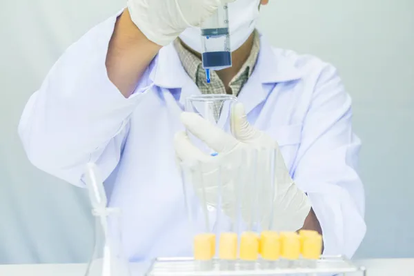 靠近点实验室研究的医务工作者用蓝色液体进行测试 实验性药物治疗 — 图库照片