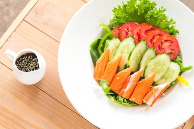 Beyaz tabakta yengeç salatası manzarası