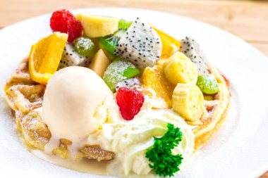 Waffle, dondurma ve meyve beyaz tabakta. 