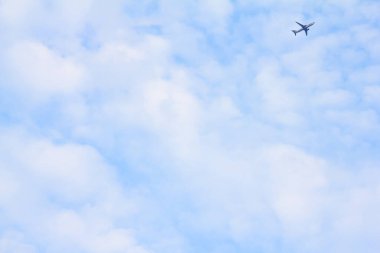 Havada bulutların arasında uçan bir uçağın görüntüsü..