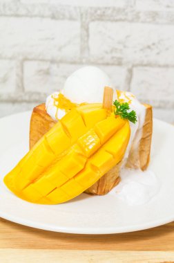 Lezzetli taze yumurta, kremalı tost ve kesilmiş mango.