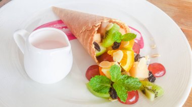 Meyveli, böğürtlenli ve beyaz tabakta naneli waffle.