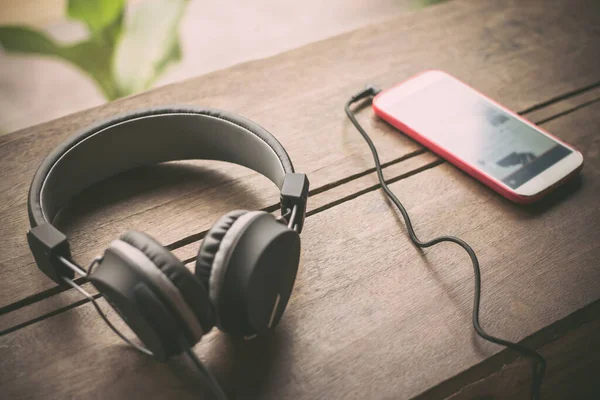 Kulaklıklar ve cep telefonları tahtaya yerleştirilmiş. 