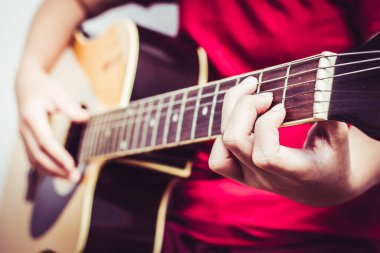 Gitar çalan ve odada şarkı söyleyen genç kadınlar..