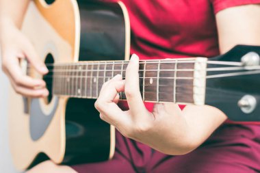 Gitar çalan ve odada şarkı söyleyen genç kadınlar..