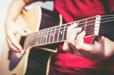 Gitar çalan, odada şarkı söyleyen genç kadınlar..