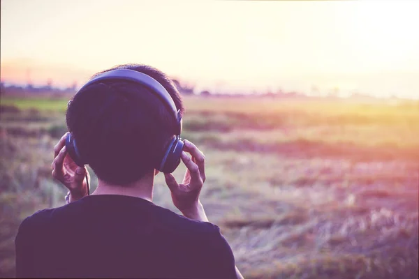 Jugendliche Hören Musik Aus Nächster Nähe Mit Einem Hellen Sonnenuntergang — Stockfoto