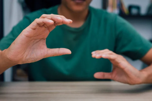 Teachers teach deaf students to learn sign language, symbols, characteristics of supporting both hands. on the wooden table in the room online learning at home