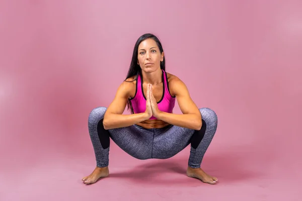 Female yoga instructor does floor exercises in gym clothes