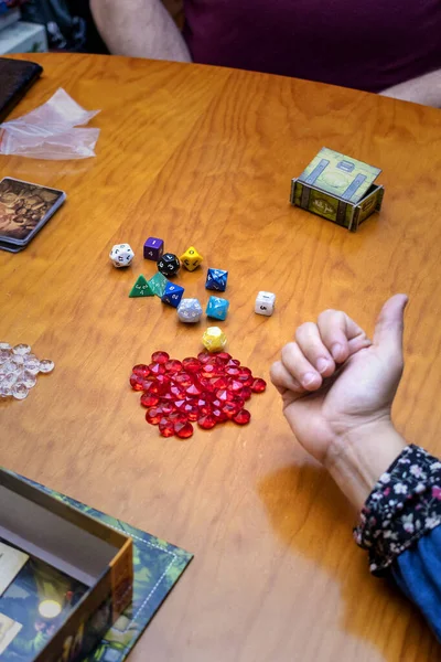 Friends playing board games. Polyhedric dice and prize jewels. Winning concept.