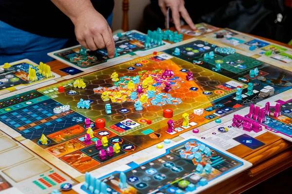 Friends playing board games. Space role-playing game about production and expansion.