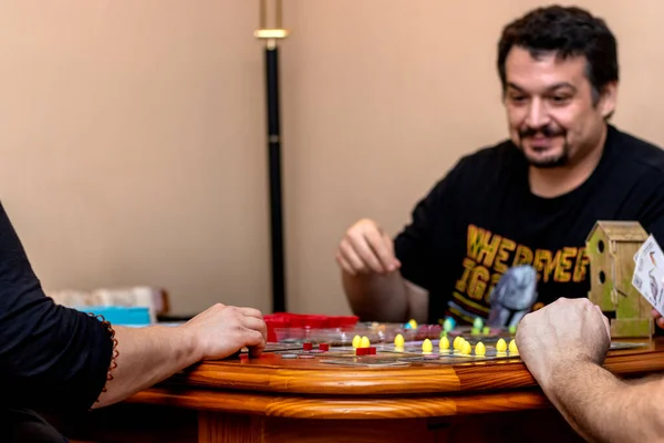 A group of friends playing board games. Enjoying with the family.