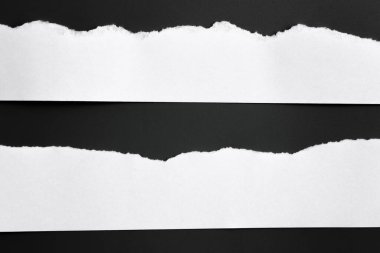 Siyah arka planda beyaz yırtık bir kağıt. koleksiyon kağıdı yırtılması