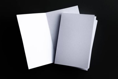 Blank Mock-up paper. brochure magazine isolated on black table, changeable background , white paper isolated on dark tone.