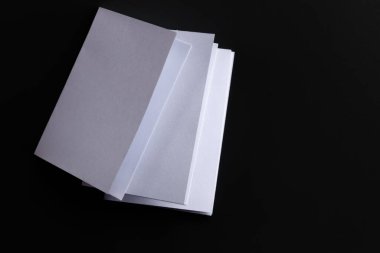 Blank Mock-up paper. brochure magazine isolated on black table, changeable background , white paper isolated on dark tone.