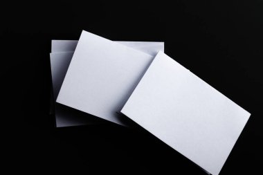 Blank Mock-up paper. brochure magazine isolated on black table, changeable background , white paper isolated on dark tone.