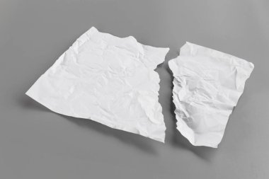 Gri arka planda beyaz yırtık kağıt. koleksiyon kağıdı yırtılması