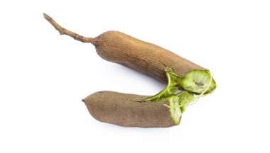 Pile of tamarind fruits on white background. Top view. Flat lay.Sticky brown acidic pulp from the pod of a tree of the pea family, widely used as a flavoring in Asian cooking.