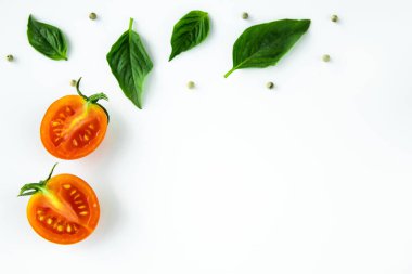 Tatlı fesleğen yaprağı ve beyaz arka planda yarım domates..