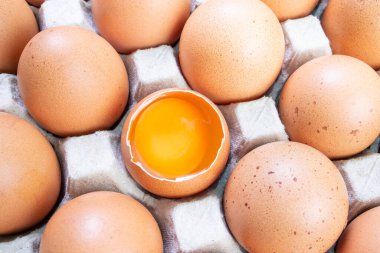 Top view, fresh chicken eggs isolated on a white background. Chicken egg is half broken among other eggs.
