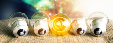 Bulbs creative ideas. One glowing light bulb standing out from the unlit incandescent bulbs with reflection , leadership and different concept.