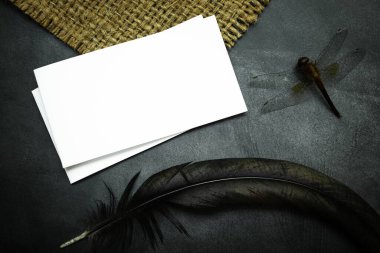 White mock-up paper and animal on black table background. Dark tone. Halloween concept. 