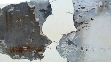 Yaşlı beyaz, paslanmış demir yüzeyden soyuluyor..