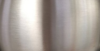 Parlak metal bir yüzeyde ışığın yansıması, paslanmaz çelik panel arka plan.