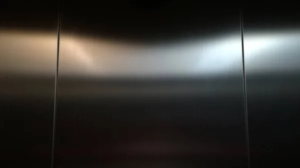 暗闇の中のステンレスシート 旅客エレベーター内 光沢のある金属表面上の光の反射 黒のステンレススチールの背景 — ストック写真