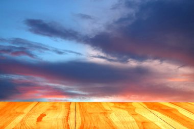 Günbatımı arkaplanlı ahşap masa balkonu alanı.