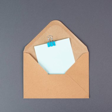 Gri arkaplan üzerine boş bir kağıda sahip zarf, metin, tebrik kartı, iletişim ve duyuru konsepti için boşluk kopyala, hatırlatma 