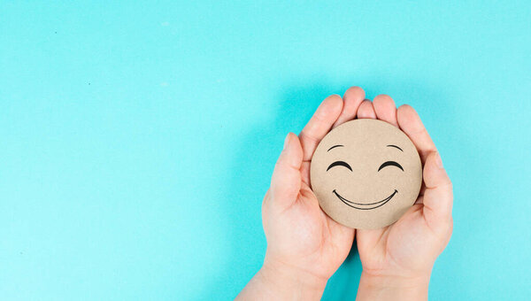 Holding a smiling happy face in the hands, positive emotions, good customer feedback 