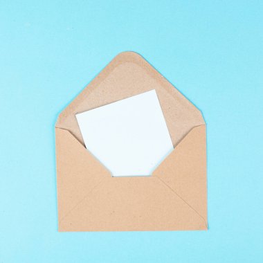 Envelope with an empty paper on a blue colored background, copy space for text, greeting card, communication and announcement concept, reminder