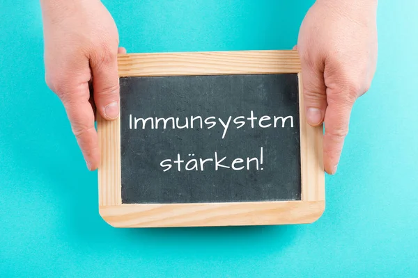 Strengthen the immune system is standing in german language on a chalkboard, healthy eating and lifestyle concept, natural protection from disease