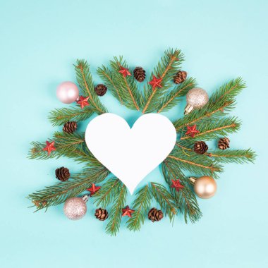Kalp şeklinde Noel tatili arkaplanı, köknar dalları, takılar ve çam kozalakları, kış mevsimi tebrik kartı çerçevesi 
