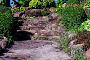 Bahçedeki patika ve merdivenlerde güneş ışığı var..