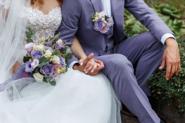 Düğünlerinde kucaklaşan bir çift. Düğünde yılın moda rengi 2022. Gelin buketi tutuyor ve damada sarılıyor Çok Peri takım elbiseli