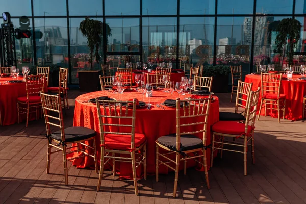 Mesa de invitados para banquete en estilo negro, rojo y dorado. Elegante y lujoso arreglo para la cena: decoración, manteles, platos, vasos, servilletas, cubiertos. Celebración temática de cumpleaños o fiesta de boda — Foto de Stock