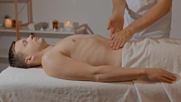 Mains masculines faisant massage pour les hommes abdomen. Massage de l'estomac. Prévention de la douleur dans le tractus gastro-intestinal avec médecine alternative. Soins corporels professionnels dans le salon SPA. — Video