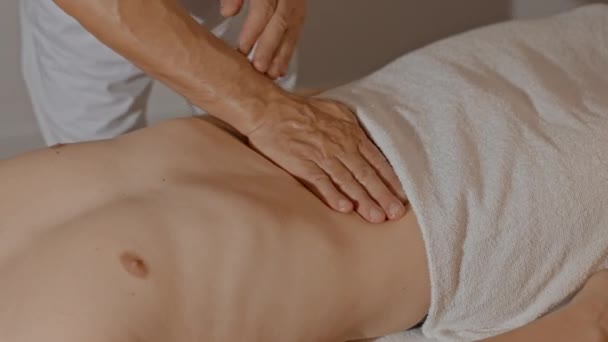 Primo piano mani maschili facendo massaggio per la pancia dell'uomo. Mascheramento dello stomaco. Prevenzione del dolore nel tratto gastrointestinale con medicina alternativa — Video Stock