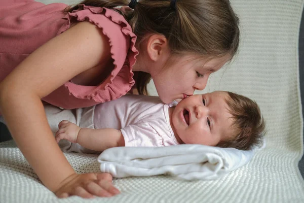 A irmã mais velha beija a menina feliz. Família feliz Fotografia De Stock