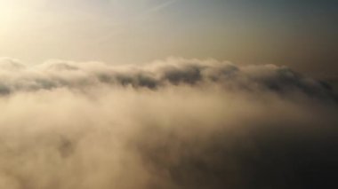 Güneş ufuk çizgisine kadar sonsuz bulut denizinin üzerinde yükseliyor. İnanılmaz doğa manzarası, gökyüzünde 4K drone. Gün doğumunda Bulutların Üzerinde Uçan Hava Manzarası. Sis şafağı