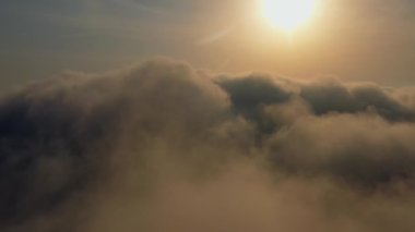 Güneş ufuk çizgisine kadar sonsuz bulut denizinin üzerinde yükseliyor. İnanılmaz doğa manzarası, gökyüzünde 4K drone. Gün doğumunda Bulutların Üzerinde Uçan Hava Manzarası. Sis şafağı