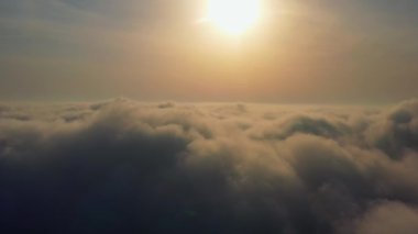 Güneş ufuk çizgisine kadar sonsuz bulut denizinin üzerinde yükseliyor. İnanılmaz doğa manzarası, gökyüzünde 4K drone. Gün doğumunda Bulutların Üzerinde Uçan Hava Manzarası. Sis şafağı