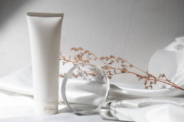 Yaşam tarzına sahip beyaz kumaş tekstil arka planı, kozmetik makyaj şişesi losyon kremi ürünü güzellik moda cilt bakım modeli.