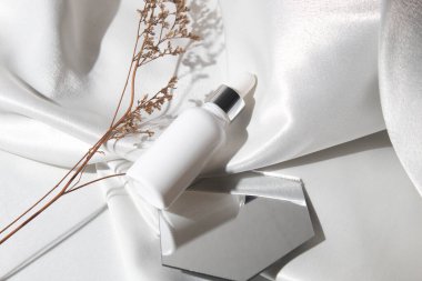 Yaşam tarzına sahip beyaz kumaş tekstil arka planı, kozmetik makyaj şişesi losyon kremi ürünü güzellik moda cilt bakım modeli.